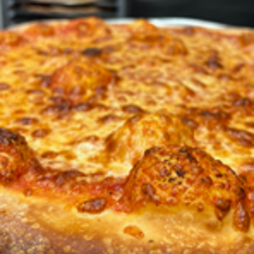 Close-up of a freshly baked Angolino Pizza with melted, bubbly cheese and a golden crust.