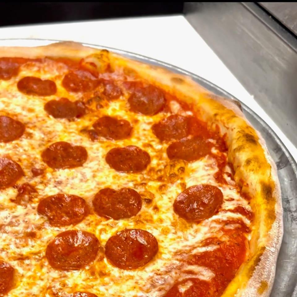 Close-up of a freshly baked Angolino pepperoni pizza with melted cheese and a golden crust.